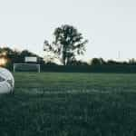 A football and a goal on an empty football field.