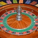 A roulette wheel surrounded by colorful betting chips.