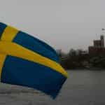 A blue and yellow flag against a cloudy and dull sky