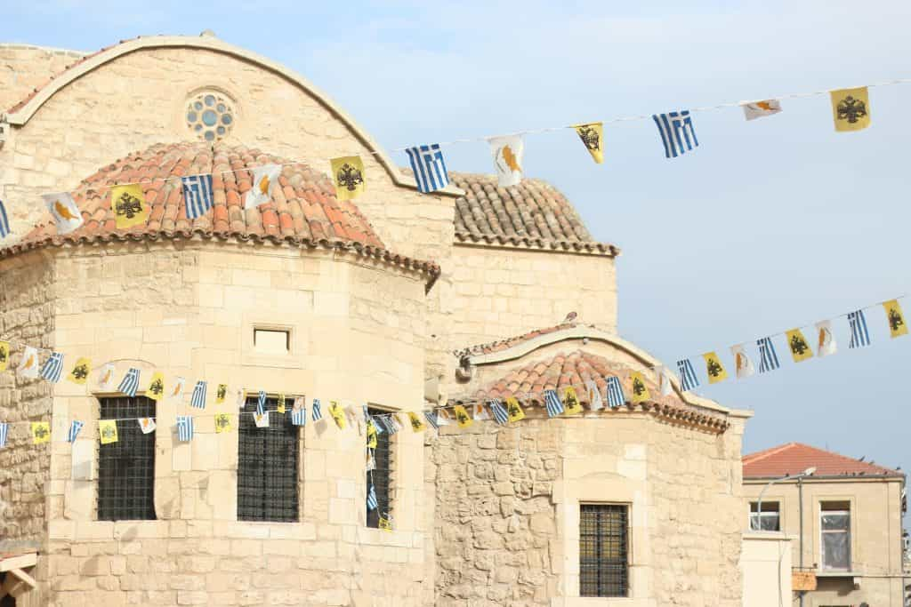 A building with multiple flags hanging from its roof.